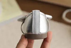 Close-up view of the heel and soft sole of silver bow princess shoes for girls