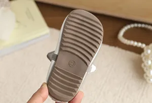 Detailed macro view showing the non-slip wavy rubber sole texture of girl's silver princess shoes