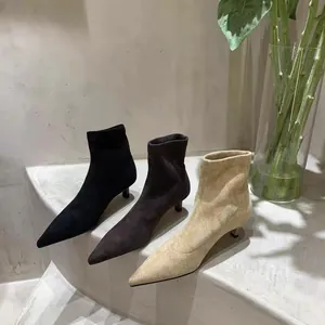 Drei Paar Wildleder-Stiefeletten mit spitzer Kappe und Pfennigabsatz in Schwarz, Braun und Beige.