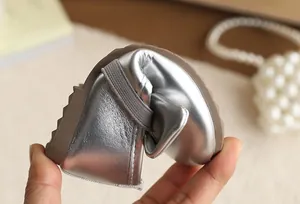 Close-up detail of silver metallic girls' princess shoe showing its flexible soft sole