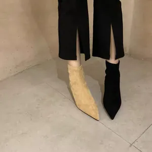 Nahaufnahme von spitzen Stiletto-Stiefeletten in Beige und Schwarz