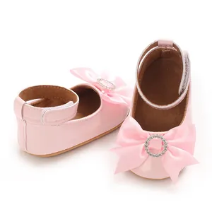 Détail rapproché de chaussures roses de princesse pour bébé avec nœud et strass