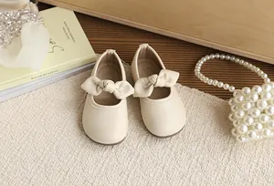 Detailed top view of cream-colored girls' Mary Jane shoes featuring a cute bow decoration