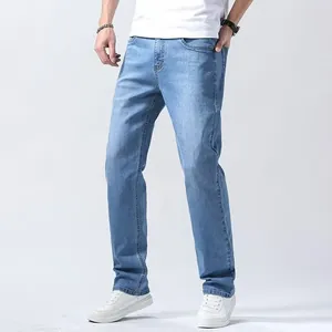 Full-length view of men's classic light blue straight-leg jeans on studio background