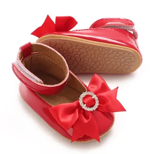 Gros plan chaussures bébé princesse rouges avec gros nœud et boucle strass