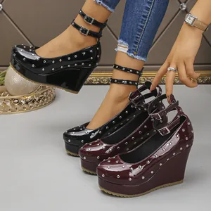 Primer plano de elegantes Mary Janes con plataforma, cuña y remaches con triple tira al tobillo