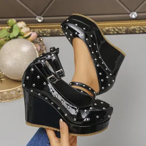 Vista detallada de zapatos de cuña Mary Jane en charol negro con tachuelas plateadas