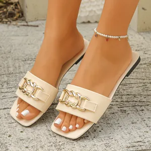 Elegant beige flat slides for women featuring a stylish gold chain detail on feet