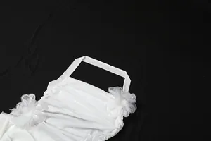 Detailansicht eines weißen Neckholder-Kleids mit eleganten Netzblumen und Raffungen