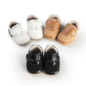 Detailed macro view of toddler sports shoes in white, brown, and black with Velcro straps