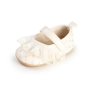 Close-up of cream baby girl walker shoe with delicate lace trim and quilted pattern