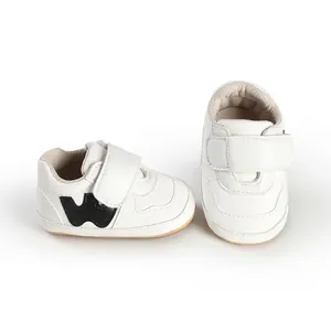 Detail view of white infant walking sneakers with hook-and-loop strap and soft sole