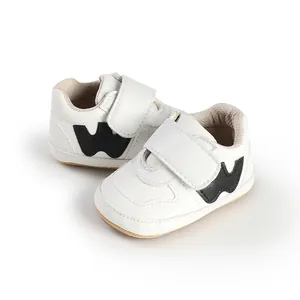 Macro view of white baby boy sneakers with velcro strap and black W logo