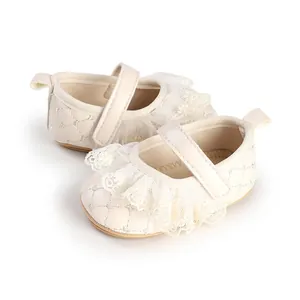 Close-up of cream baby walker shoes with delicate lace ruffles and quilted pattern.