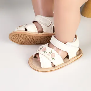 Close-up of white baby sandals with floral embroidery and soft non-slip sole