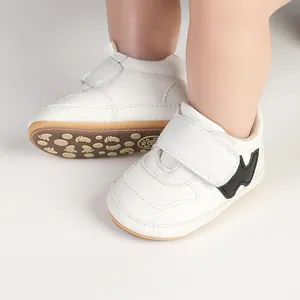 Close-up of white baby walking shoes featuring Velcro closure and patterned sole