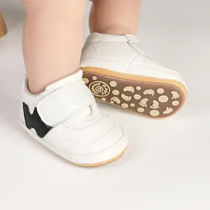White baby boy walking sneakers with velcro straps and non-slip rubber soles detail
