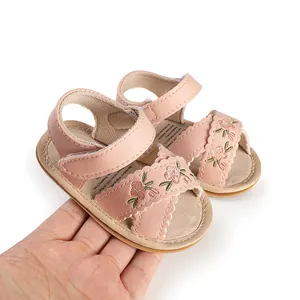 Detailed view of pink baby pre-walker sandals with floral embroidery and velcro straps.