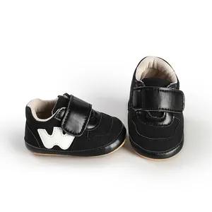 Detail view of black infant baby sports sneakers with soft soles and velcro closure