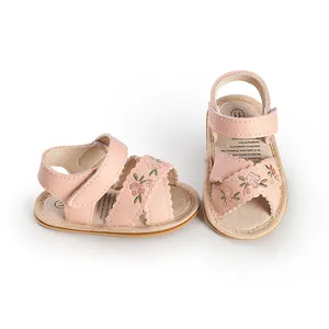 Detailed view of pink baby walking sandals with floral embroidery and velcro straps.