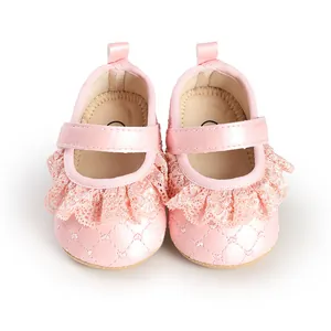 Detail view of pink baby girl princess shoes with delicate lace ruffles and quilted satin