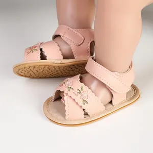 Pink baby sandals with delicate floral embroidery and scalloped edges for infants