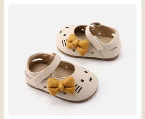 Detail of toddler girl walking shoes with cartoon cat design and yellow bow accent
