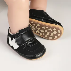 Detailed macro view of black infant walker shoes featuring a non-slip rubber sole