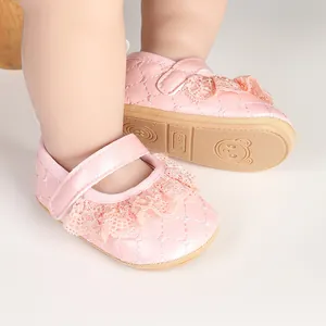 Detailed macro view of pink baby princess shoes with lace trim and quilted pattern