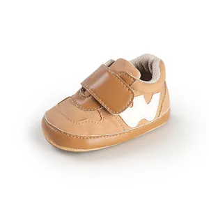Side view of tan baby walking shoes with white decorative patch and velcro strap
