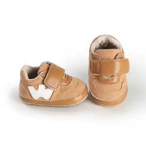 Detail shot of brown baby boy velcro sneakers with soft soles and a white W logo