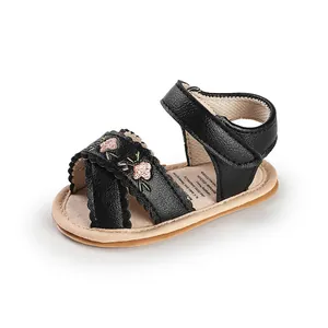 Detail view of black faux leather baby walking sandals featuring pink floral embroidery