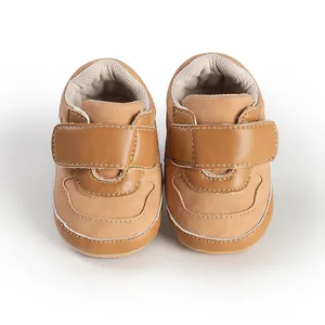 Close-up front view of tan faux leather baby pre-walker shoes featuring velcro straps