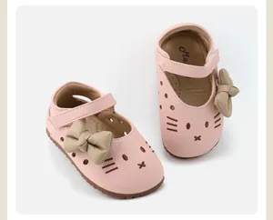 Detailed view of pink baby girl walking shoes with cartoon cat face and khaki bow