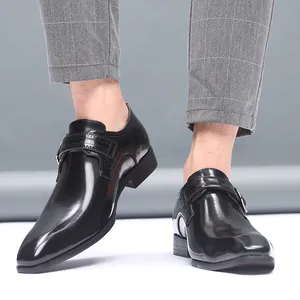Vue détaillée des chaussures habillées noires à boucle pour hommes, bout pointu.