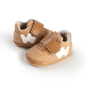 Professional studio shot of soft tan baby sneakers with white W logo and velcro strap