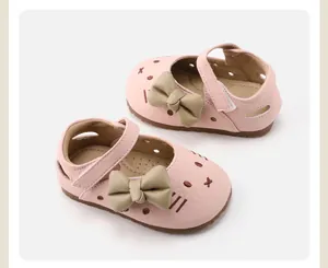 Detailed view of pink baby girl Mary Jane shoes with khaki bows and cat embroidery