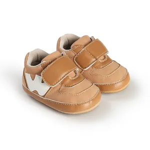 Macro view of brown faux leather baby sneakers showing soft texture and strap detail