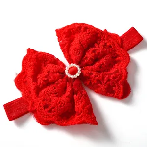Detailed macro view of a red lace princess bow baby headband decorated with pearls