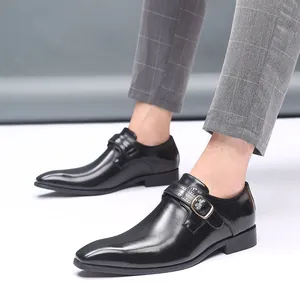 Détail de chaussures en cuir noir pour hommes avec boucle métallique et bout pointu élégant