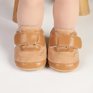 Detailed close-up of brown infant pre-walker sneakers with hook and loop strap