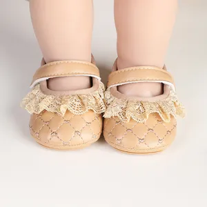 Close-up detail of beige baby girl walking shoes with delicate lace trim and quilted pattern