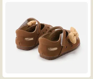 Detail view of brown baby girl shoes with cute yellow bow and cat ears