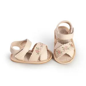 Detail view of these beige infant sandals with floral embroidery and soft soles