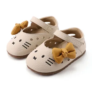 Cream baby girl walking shoes featuring cartoon cat design and mustard yellow bow