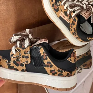 Nahaufnahme von Leoparden-Sneakern für Kinder mit weicher Sohle und Flechtkordeln.