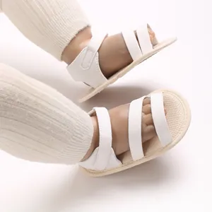 Nahaufnahme von leichten weißen Lauflern-Sandalen für Babys mit weichen Sohlen für den Sommer