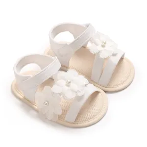 Detailansicht weißer Baby-Sandalen mit Blumenverzierung und weicher Sohle für Babys.