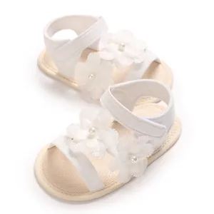 Detaillierte Ansicht weißer Babysandalen mit eleganten Gänseblümchen aus Spitze und Perlen