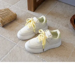Close-up of children's white sneakers with yellow laces and light green heel detail